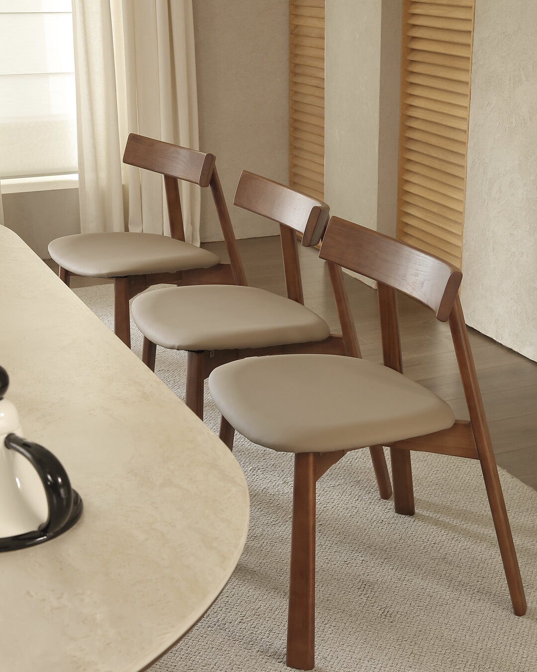 Three Geneva chairs along the table, showing the shaped wood backrest