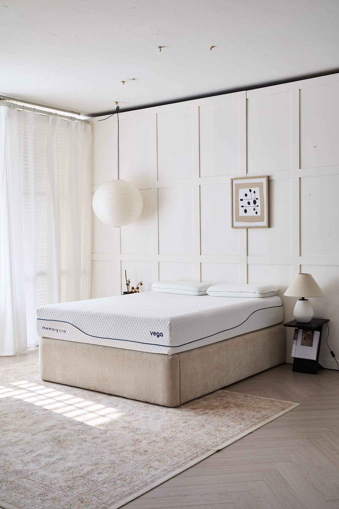 The Vega in a sunlit bedroom, made up with two pillows